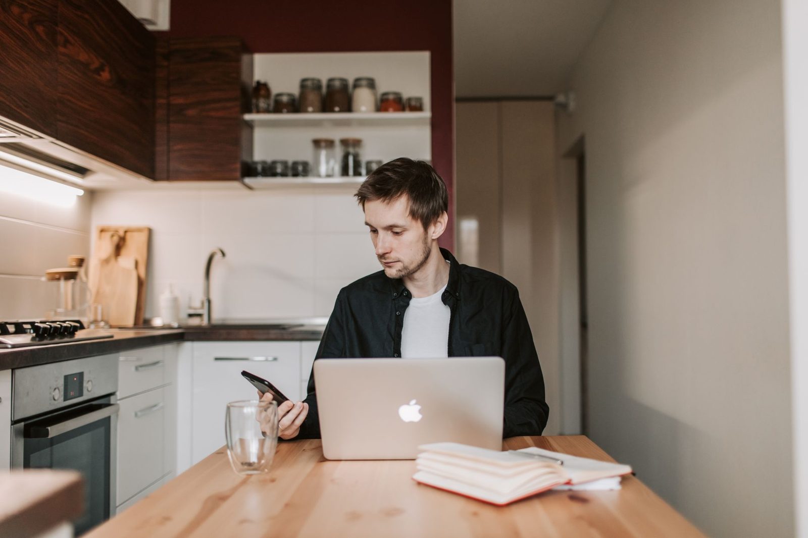 Man working on a laptop at a kitchen table